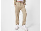 Pantalon de survêtement beige et sweat à capuche assorti, avec des baskets blanches.