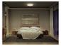 Chambre douillette avec un lit, un tapis et un plafonnier créant un éclairage chaleureux.