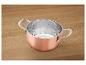 Casserole en cuivre avec échelle de mesure sur une surface en bois.