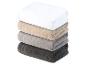 Une pile de serviettes de bain en blanc, beige, gris et gris foncé.