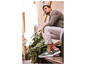 Un homme portant des baskets vertes et un pantalon blanc est assis sur un banc dans une ruelle.