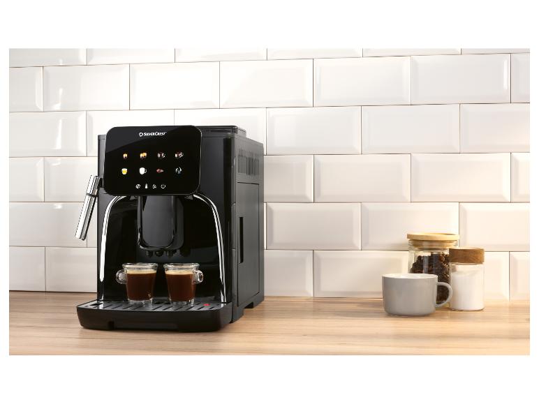 Machine à café noire avec deux tasses de café, des bocaux et une tasse sur un comptoir en bois.
