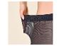Femme tirant sur la ceinture élastique d'un collant noir.
