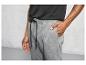 Homme portant un pantalon de survêtement gris avec un cordon noir