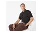 Homme en polo noir et pantalon marron assis sur une chaise.