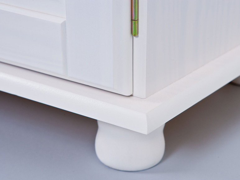 Armoire en bois blanche avec des pieds ronds.