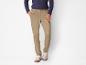 Pantalon chino beige avec des baskets blanches.