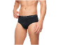 Homme en slip noir, ajustant la taille avec sa main.