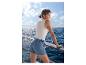 Femme en short en jean ESMARA® sur un bateau avec vue sur la mer.