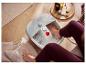 Une personne se relaxe les pieds dans un bain de pieds Sensoplast.