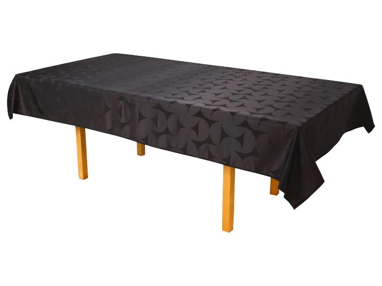 Nappe noire à motif géométrique sur une table en bois.