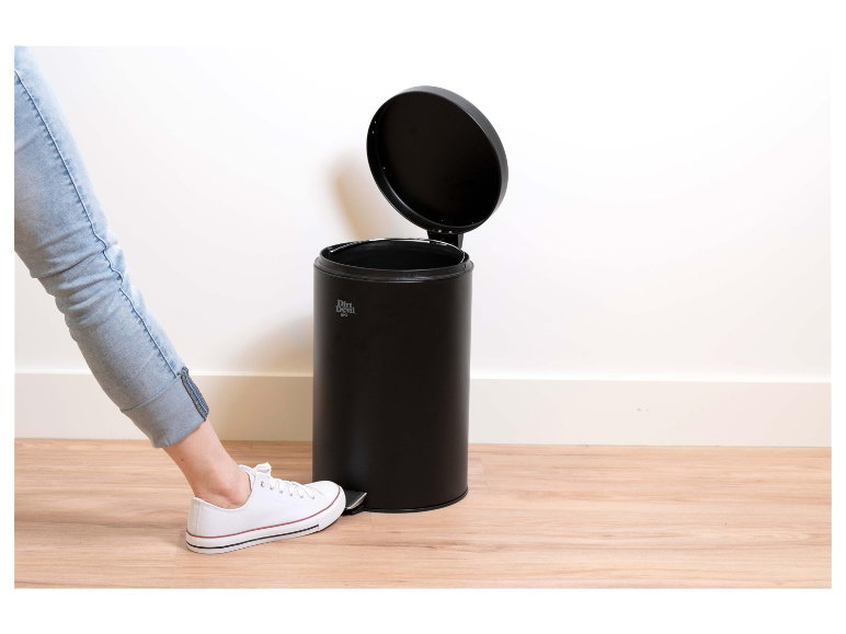 Un pied ouvre une poubelle noire Dirt Devil.