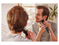 Un homme se rase la barbe avec une tondeuse Braun.