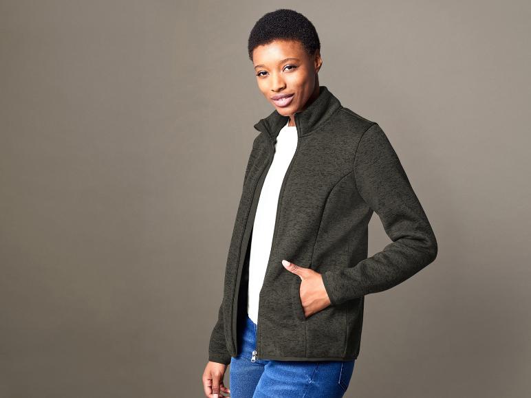 Femme avec une veste verte et un jean