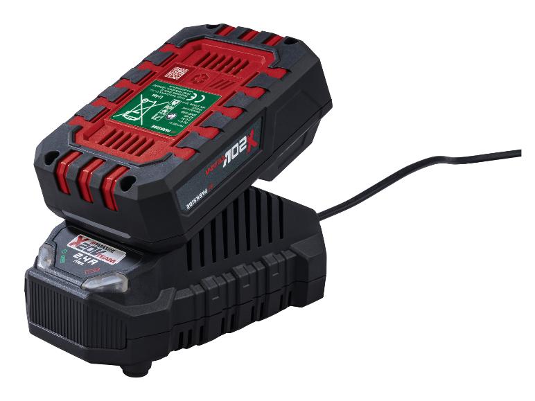 Une batterie d'outil électrique rouge et noire en charge sur un chargeur noir, avec un câble sortant du chargeur.