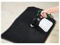 Un tapis de sol de voiture noir est nettoyé à l'aide d'un vaporisateur et d'une brosse.