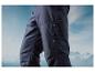 Pantalon bleu marine avec fermeture éclair sur un fond de montagnes enneigées.