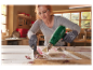 Une femme utilise un décapeur thermique Parkside pour enlever de la peinture d'une porte.