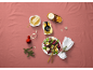 Pot de miel, salade et décorations de Noël sur une nappe rose.