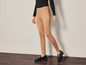 Leggings en daim marron avec des mocassins noirs.