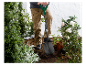 Un homme utilise une pelle Parkside pour jardiner.