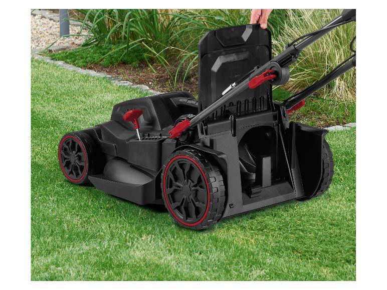 Tondeuse à gazon sans fil avec des accents rouges sur l'herbe verte, une main ouvre le couvercle supérieur.