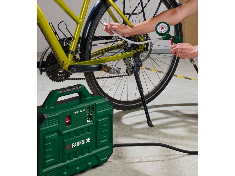 Compresseur vert gonflant un pneu de vélo.