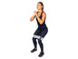 Une femme fait des squats avec un élastique de résistance.