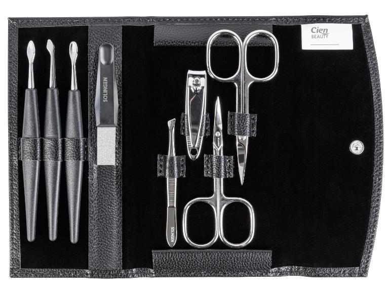 Une trousse en cuir noir avec des outils de manucure, comprenant deux ciseaux, un coupe-ongles et une lime.