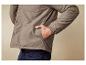 Un homme porte une veste beige à boutons et une poche.