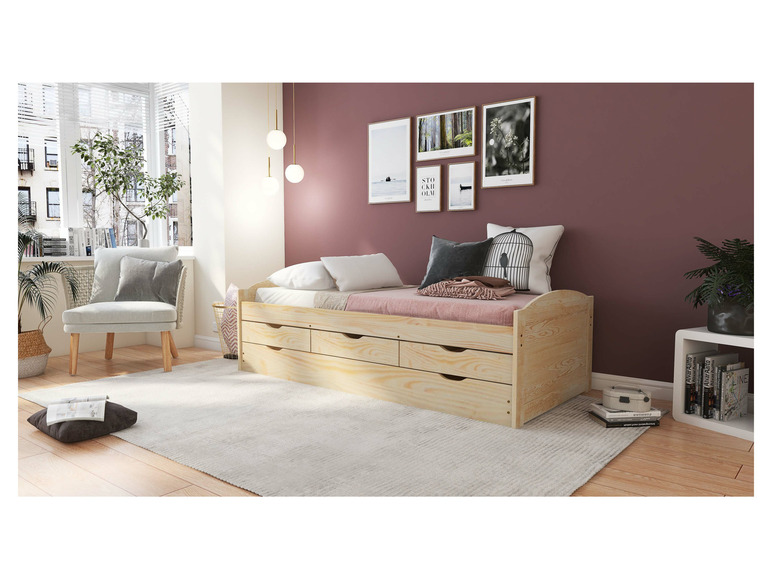 Un lit en bois avec des tiroirs dans une chambre avec une chaise.