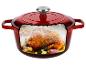 Cocotte en fonte rouge avec un poulet rôti, de l'ail et des herbes à l'intérieur.