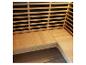 Intérieur de sauna en bois clair avec banc en L et dossier à lattes.