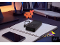Batterie externe noire sur un carnet, avec un smartphone et une décoration de cerf pixelisée.