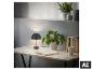 Lampe de table noire sur un bureau en bois avec plantes et livres