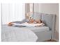 Une femme dort paisiblement sur un lit avec un oreiller de grossesse.
