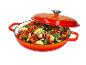 Cocotte orange avec couvercle, remplie de légumes coupés comme des courgettes, poivrons et oignons.