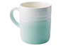 Une tasse Le Creuset bleue avec un bord blanc.