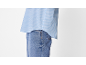 Chemise rayée bleu clair et jean délavé clair.