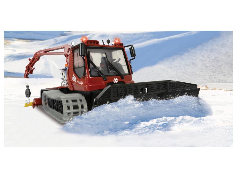 Motoneige rouge PistenBully 600 en action sur un champ enneigé
