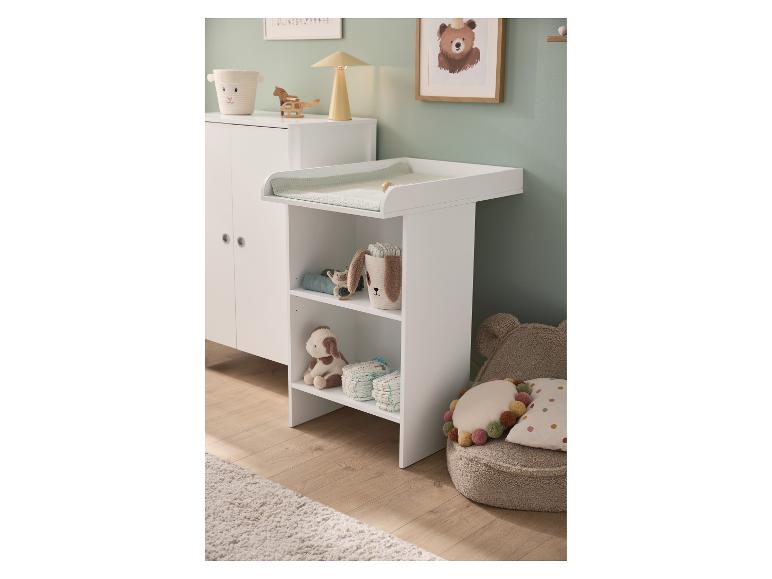 Table à langer blanche avec étagères, armoire et décoration de chambre de bébé.