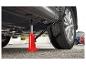 Un cric hydraulique rouge levant une voiture.