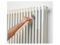 Une main peint un radiateur avec un pinceau Parsijoe.
