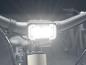 Un gros plan d'un guidon de vélo avec un phare lumineux.