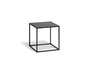 Une table d'appoint en métal noire avec un plateau en verre.