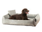 Un labrador brun dans un lit pour chien gris de Rohrschneider.