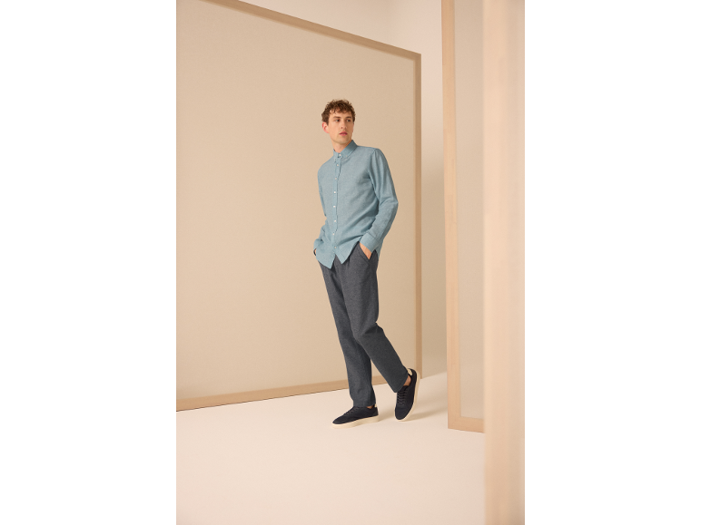 Homme en chemise bleu clair et pantalon bleu foncé.