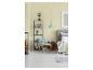 Chambre avec lit, fauteuil, étagère, pile de bois et suspension vert menthe.