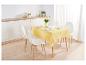 Une nappe jaune avec un motif blanc sur une table à manger avec des chaises blanches.