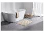 Baignoire, tapis de bain beige à motifs floraux et serviette.
